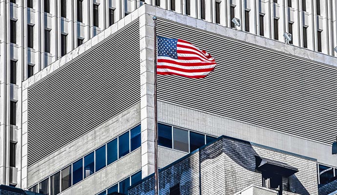 American flag flying outside a multistory government office building