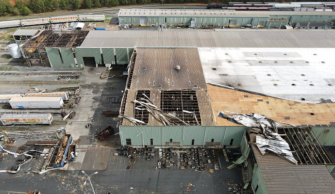 Large commercial property showing extensive roof damage caused by a severe storm