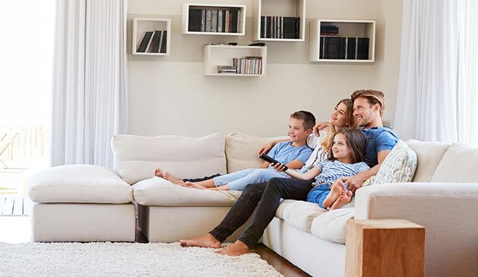 Family sitting together on sofa in a clean room