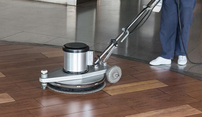 A person cleaning floor with equipment