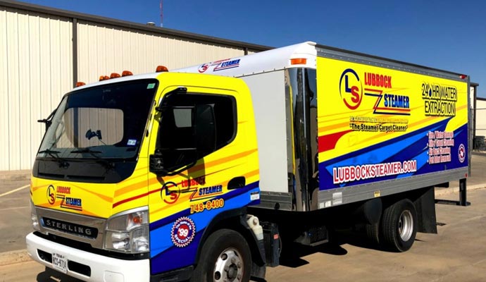 A Lubbock Steamer vehicle outside buildings