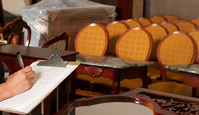 Person checking inventory list of stored furniture