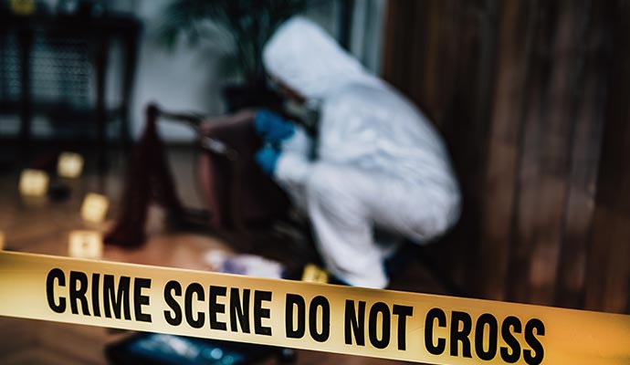 A person cleaning biohazard in a crime zone