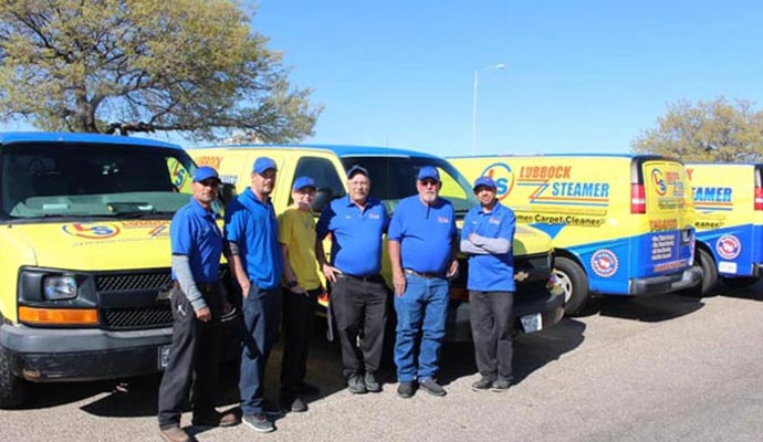 Service providers standing in front of service vehicles of Lubbock Steamer