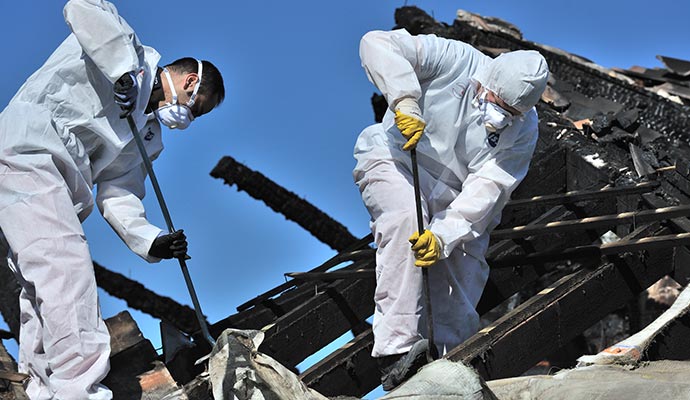 Two people cleaning fire damaged property