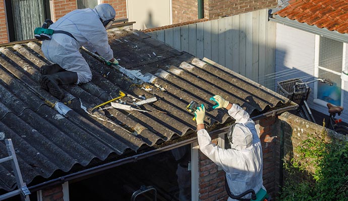 Two people removing asbestos