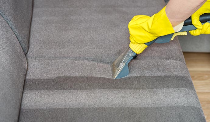 A person cleaning upholstery A person cleaning upholstery