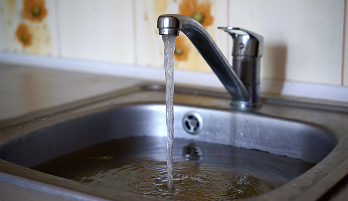 Kitchen sink overflowing with water from a faucet